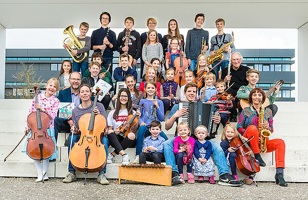 Gruppenfoto mit Musikschülerinnen und -schülern mit Instrumenten